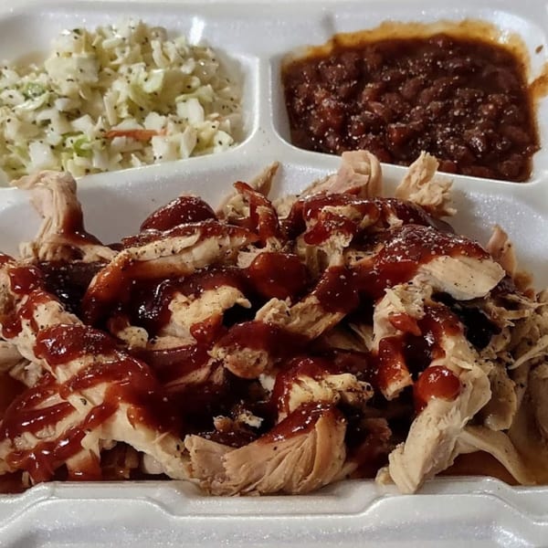 Pappies Smokehouse & Lunch Box BBQ chicken with coleslaw and baked beans in a styrofoam container.
